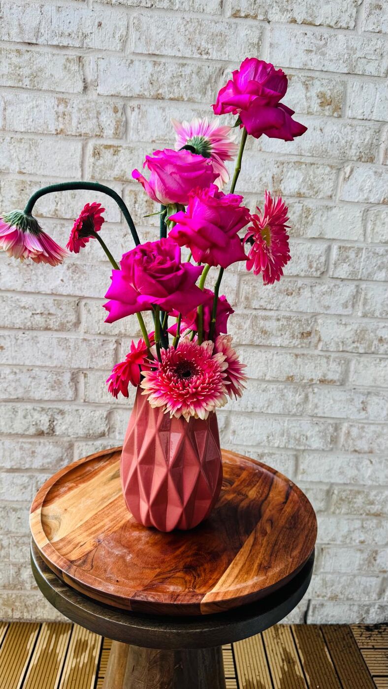 Hot-pink roses and bicolor gerbera daisies in a faceted blush vase